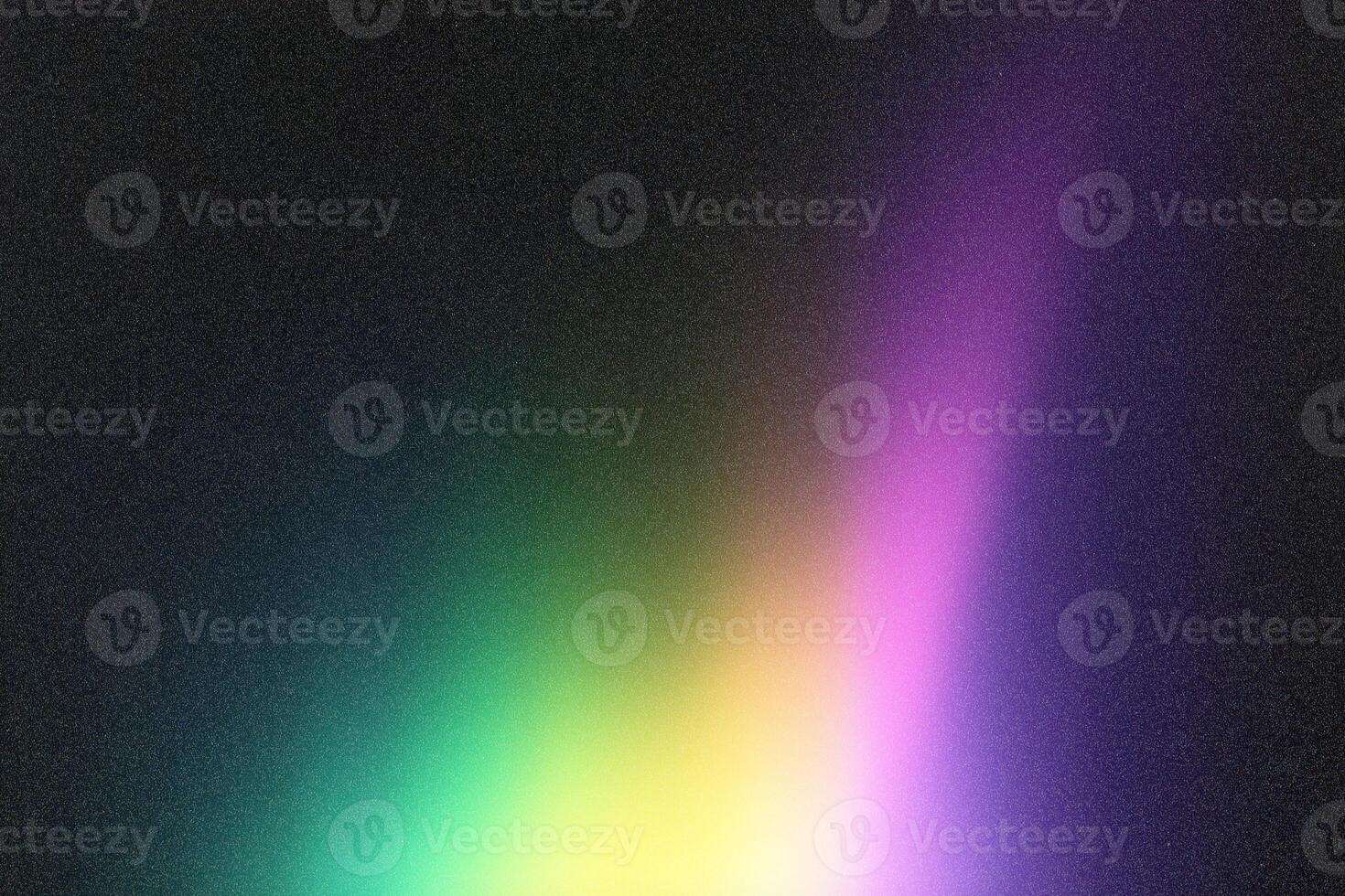 Colorful gradient background blending green, yellow and purple on grainy black surface photo