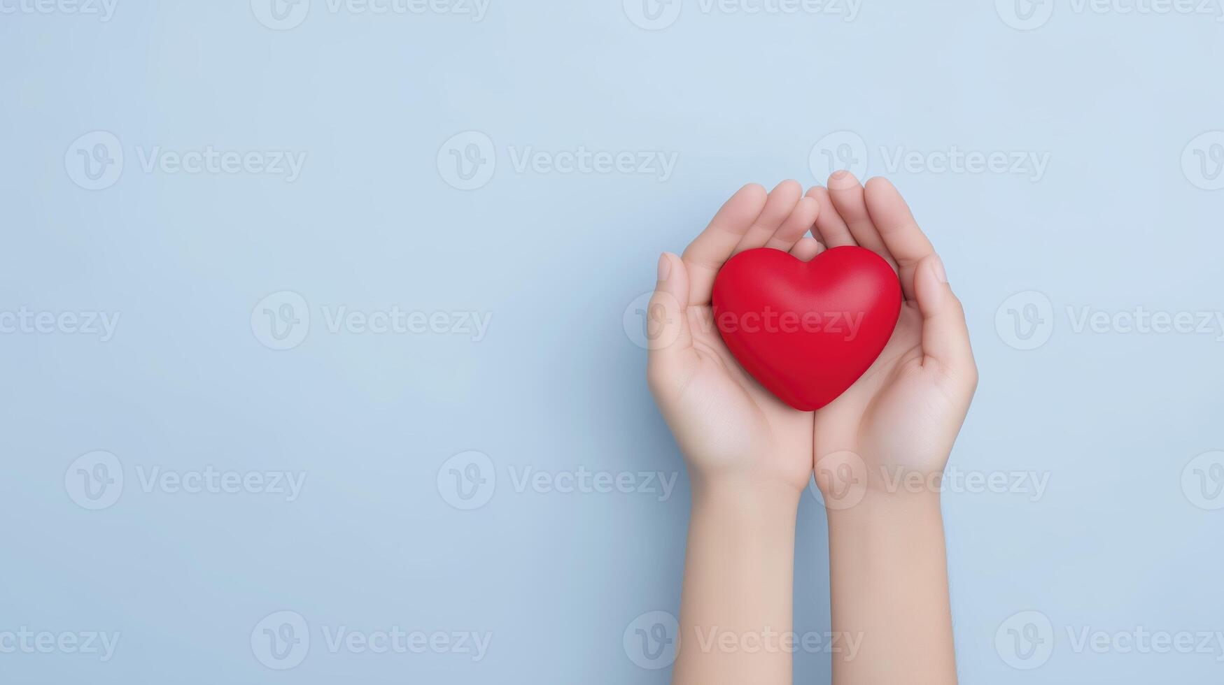 Hands gently holding a vibrant red heart against a soft blue background, symbolizing love, care, and compassion in a visually appealing and emotional context photo