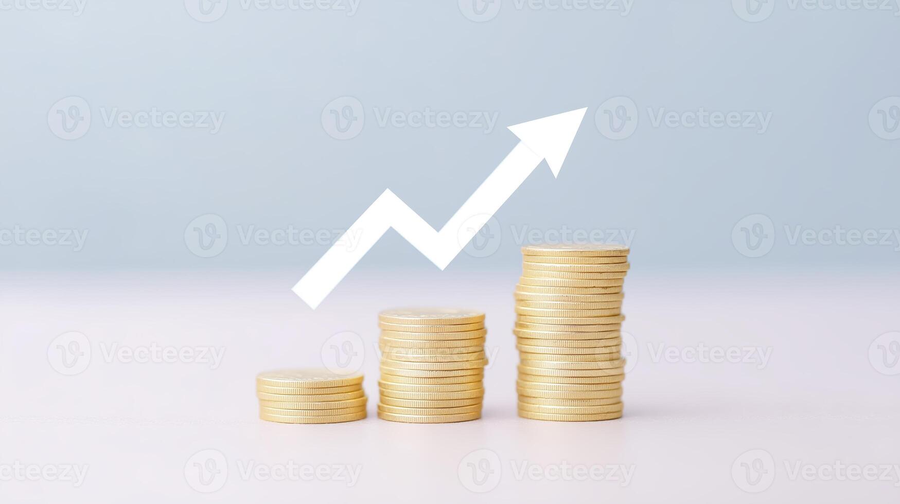 Stacks of golden coins arranged in ascending order with a white upward arrow symbolizing financial growth and success against a soft blue background, representing investment and prosperity photo