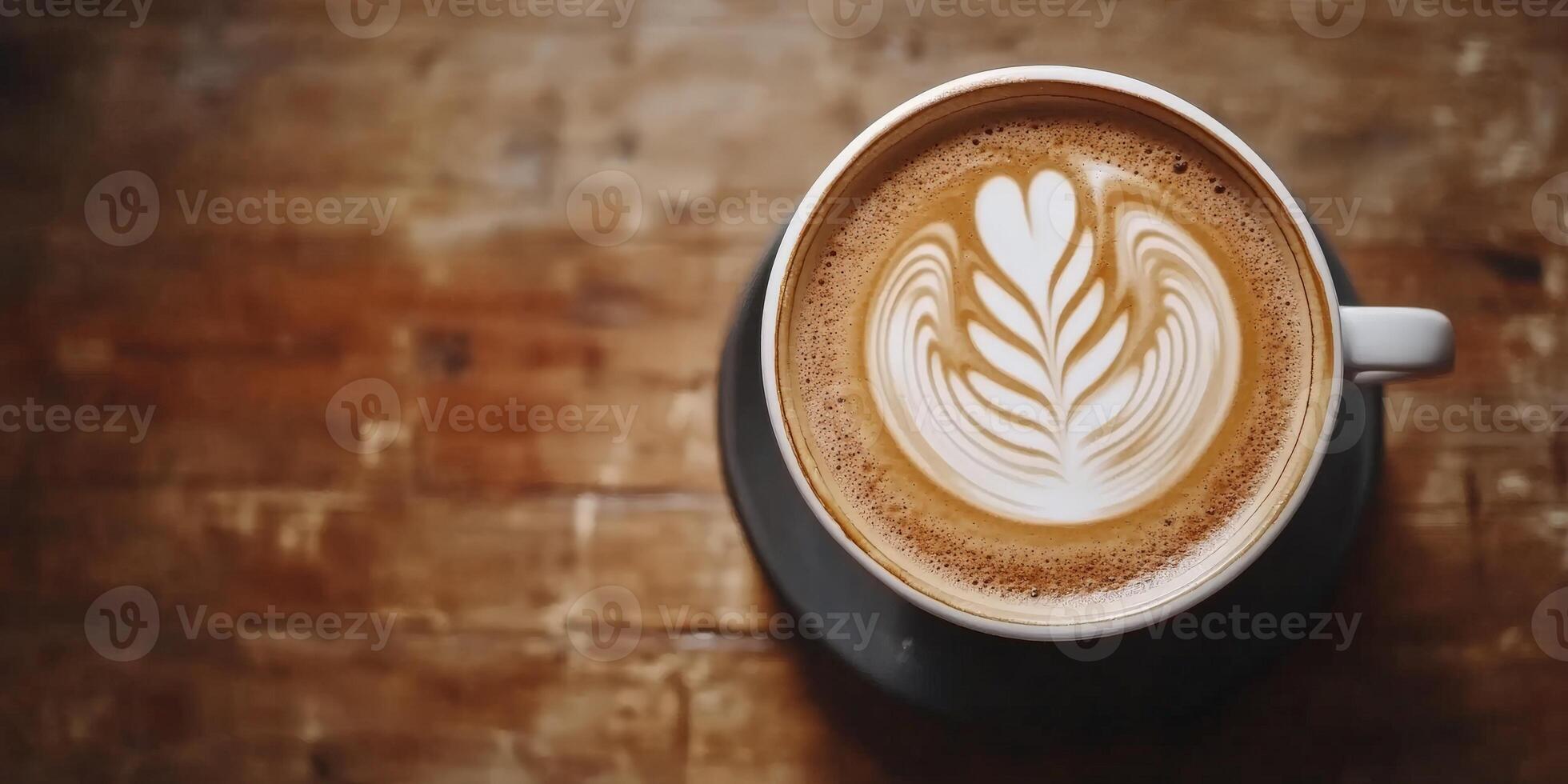 Overhead View of Coffee Latte Art in White Ceramic Cup on Wooden Table photo
