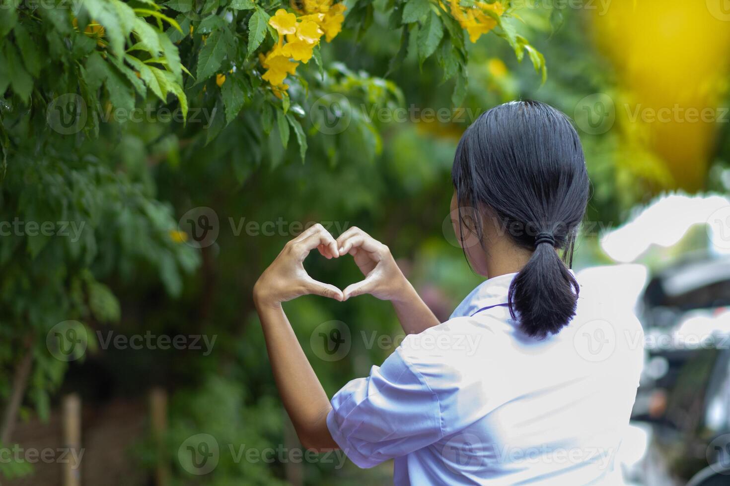 A woman making a heart shape with her hands photo