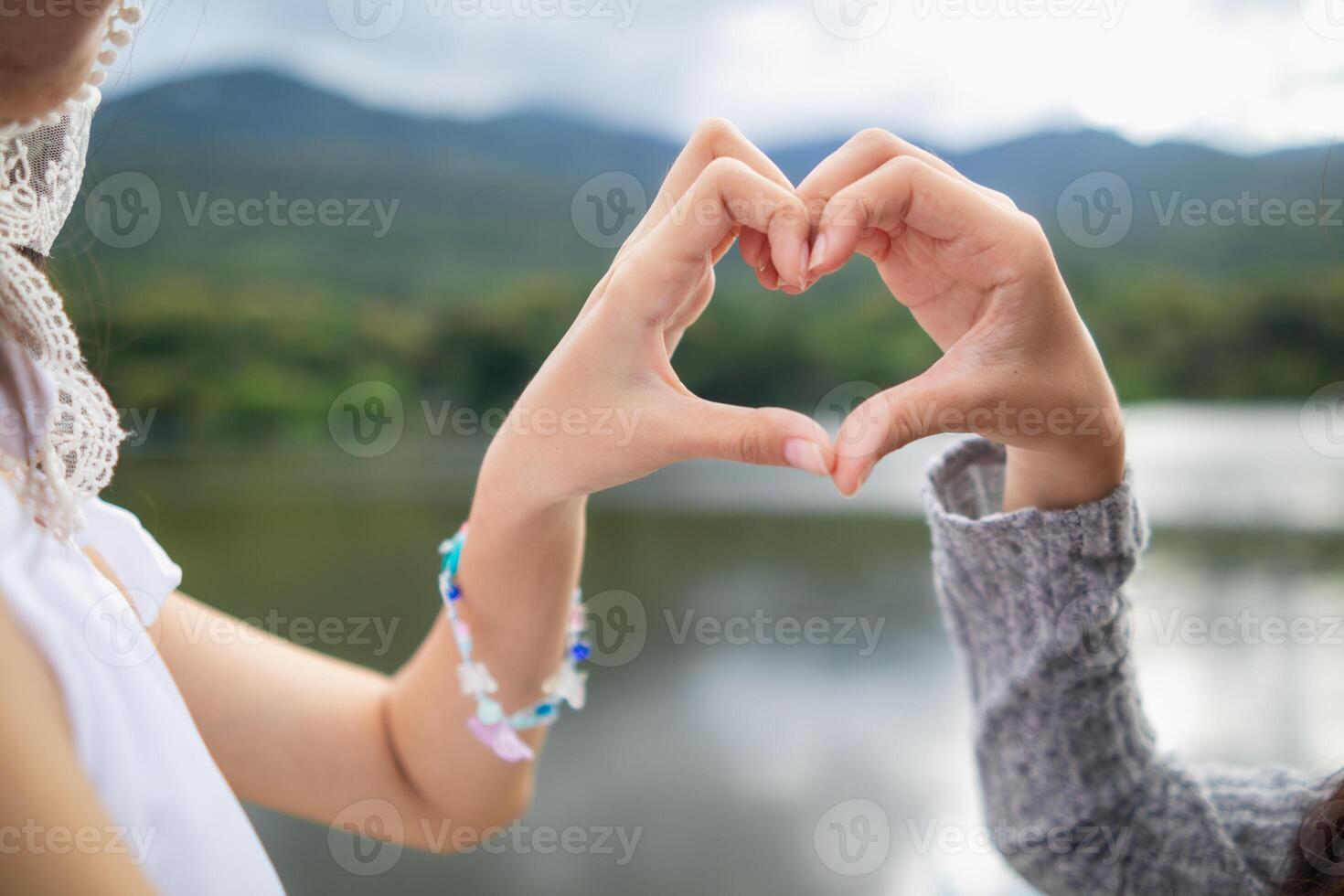Two women making a heart shape with their hands photo