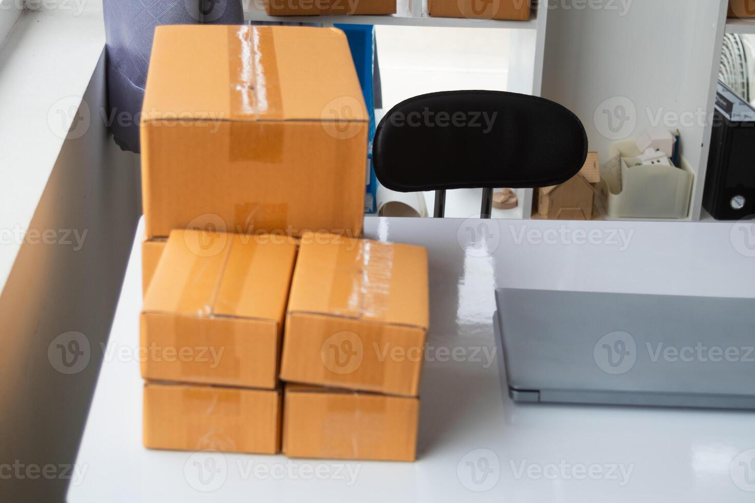 A stack of boxes on a desk next to a laptop photo