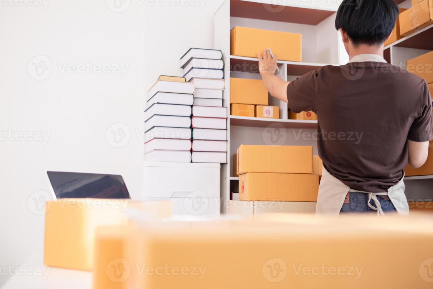 A man is standing in front of a shelf with boxes photo