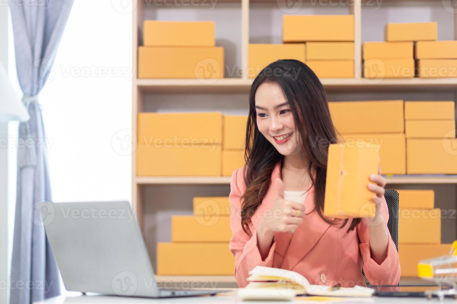 Asian woman holding a box of orange boxes photo