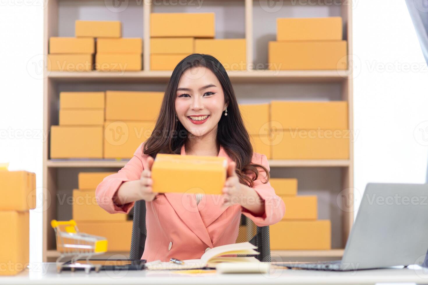 A woman is holding a box with a laptop photo