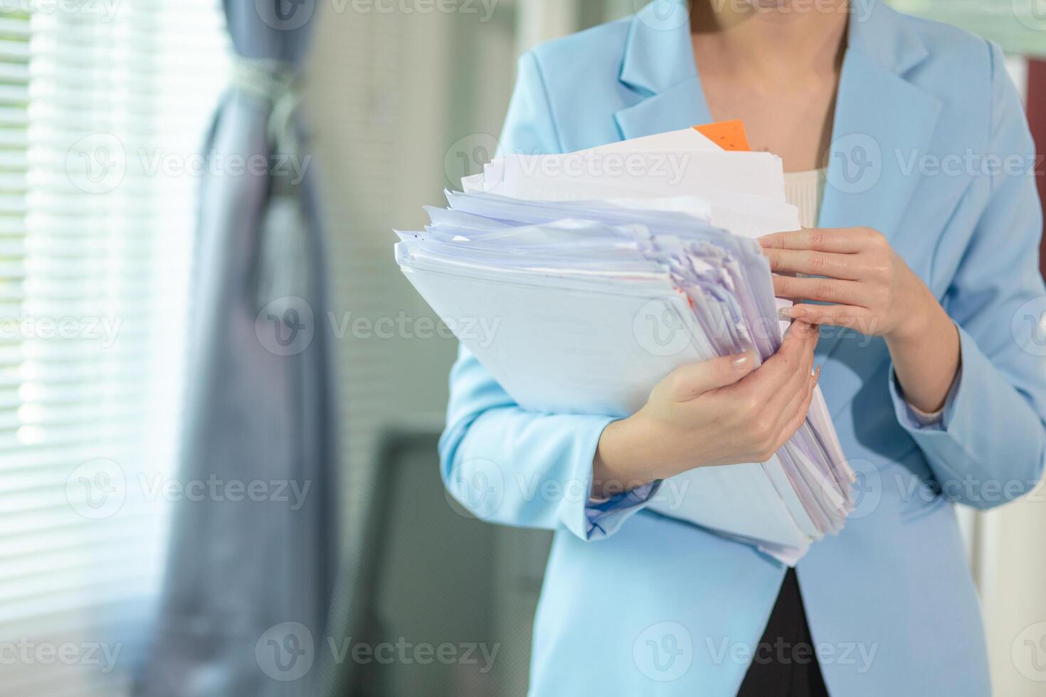 A woman in a business suit holding a stack of papers photo