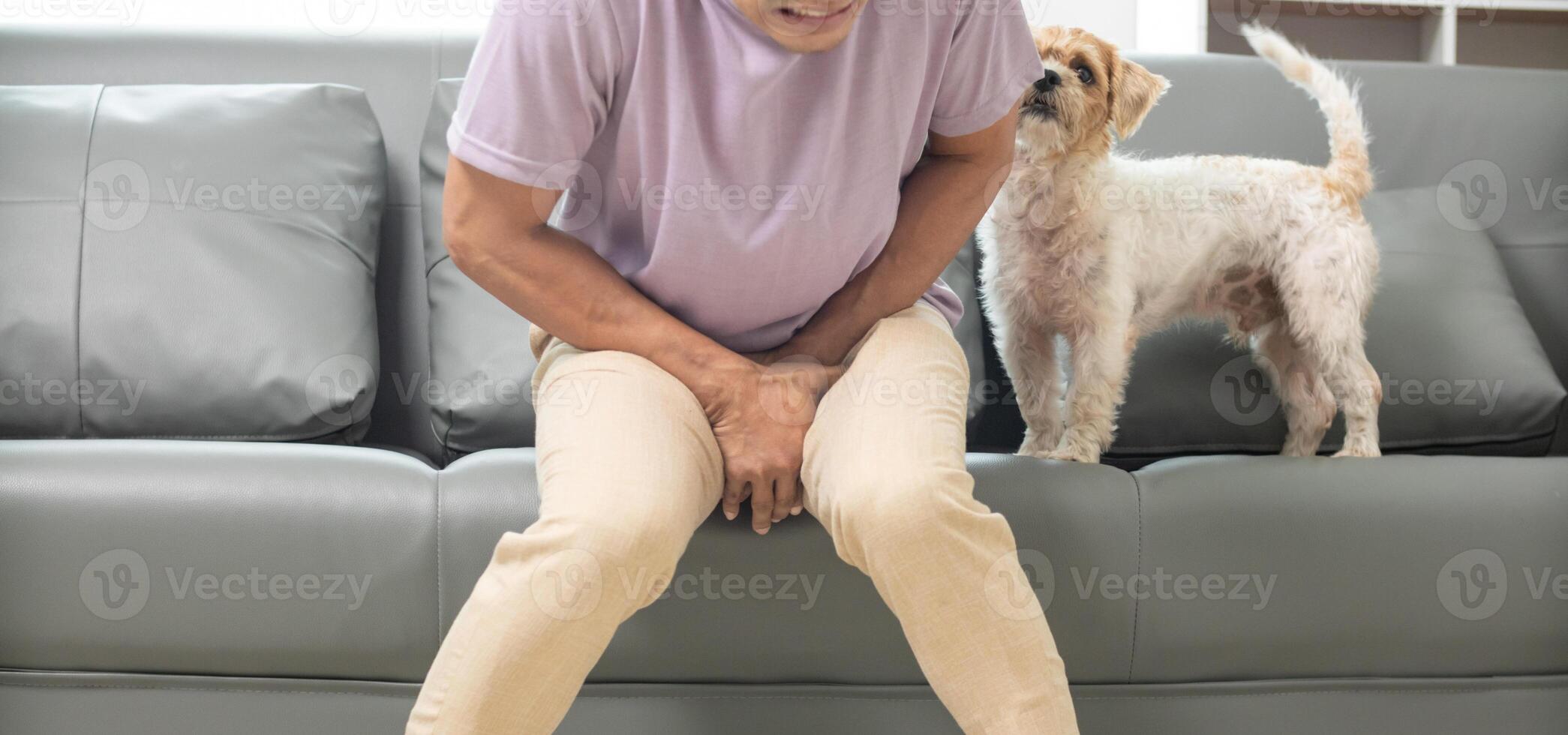 A man sitting on a couch with his dog photo
