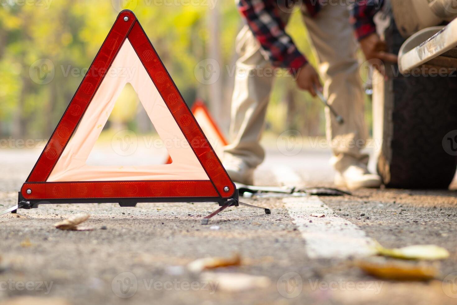 A man is fixing a car on the side of the road photo