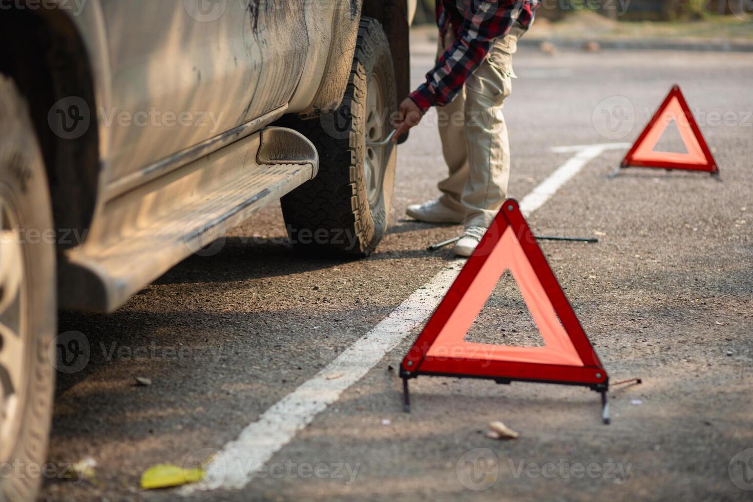 A man is fixing a tire on a car photo