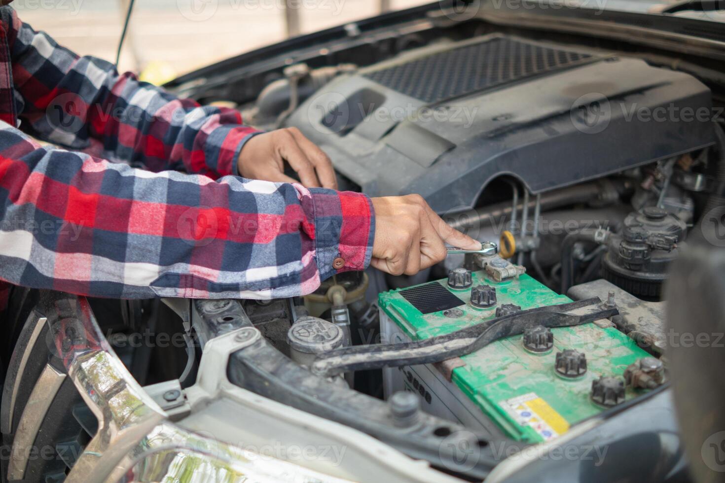 A man is working on the engine of a car photo