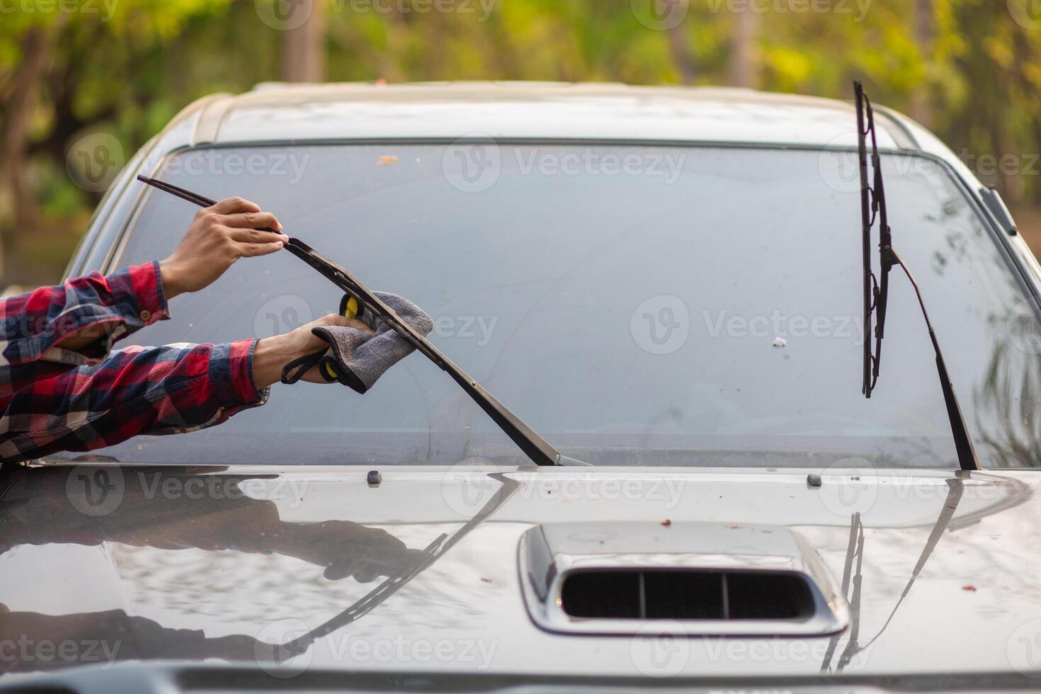 A man is using a car windshield wiper to clean it photo