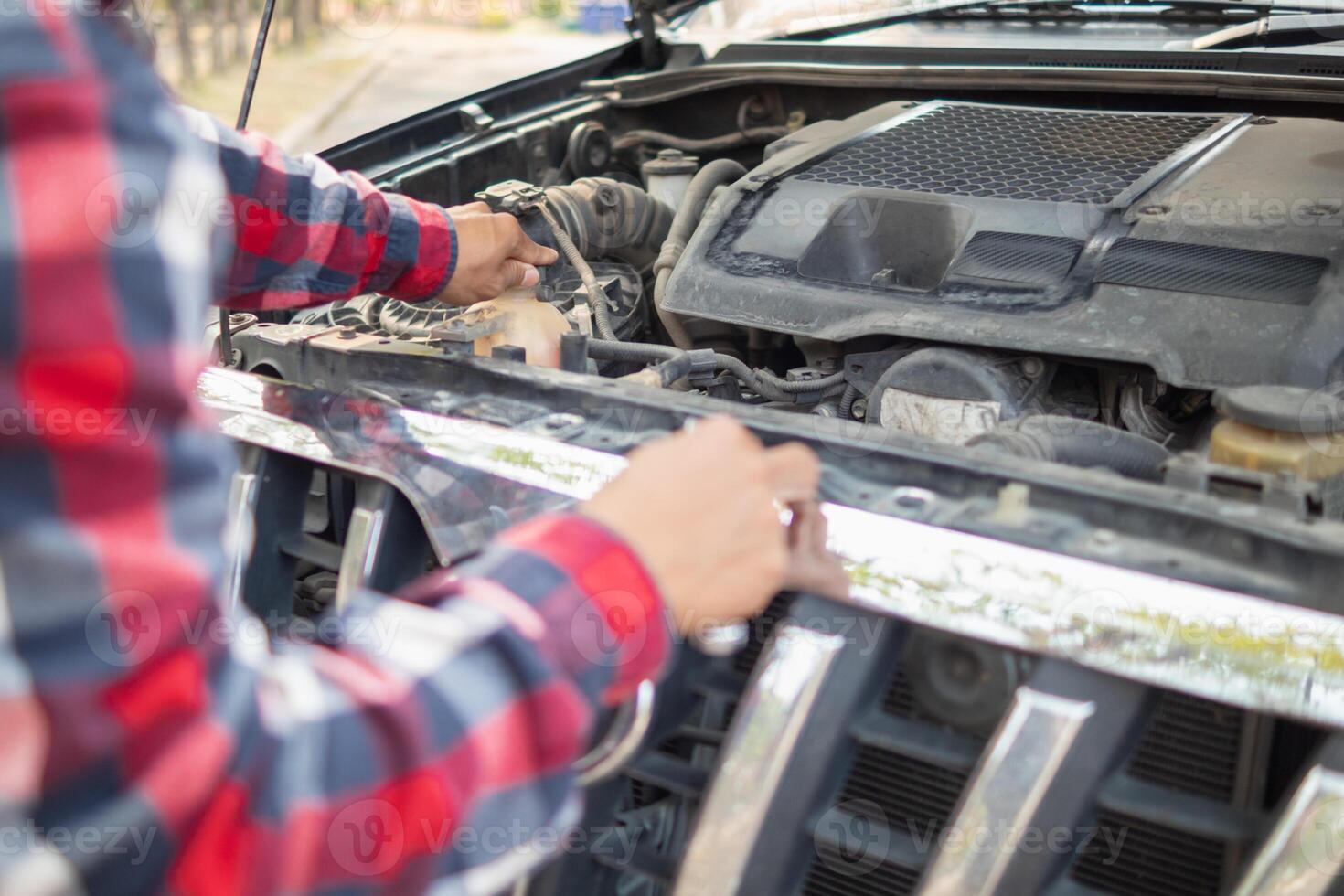 A man is fixing the engine of a car photo