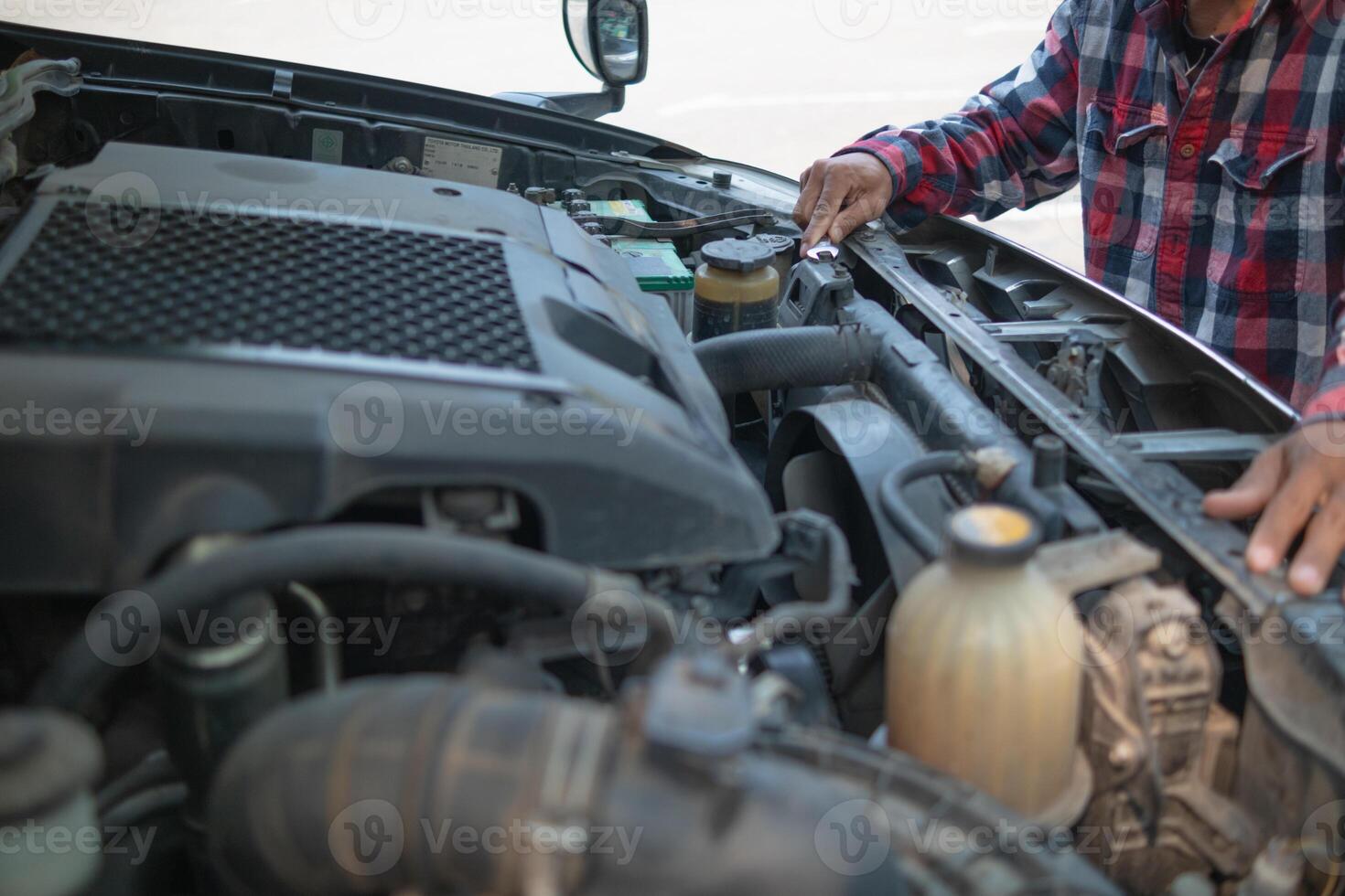 A man is checking the engine of a truck photo