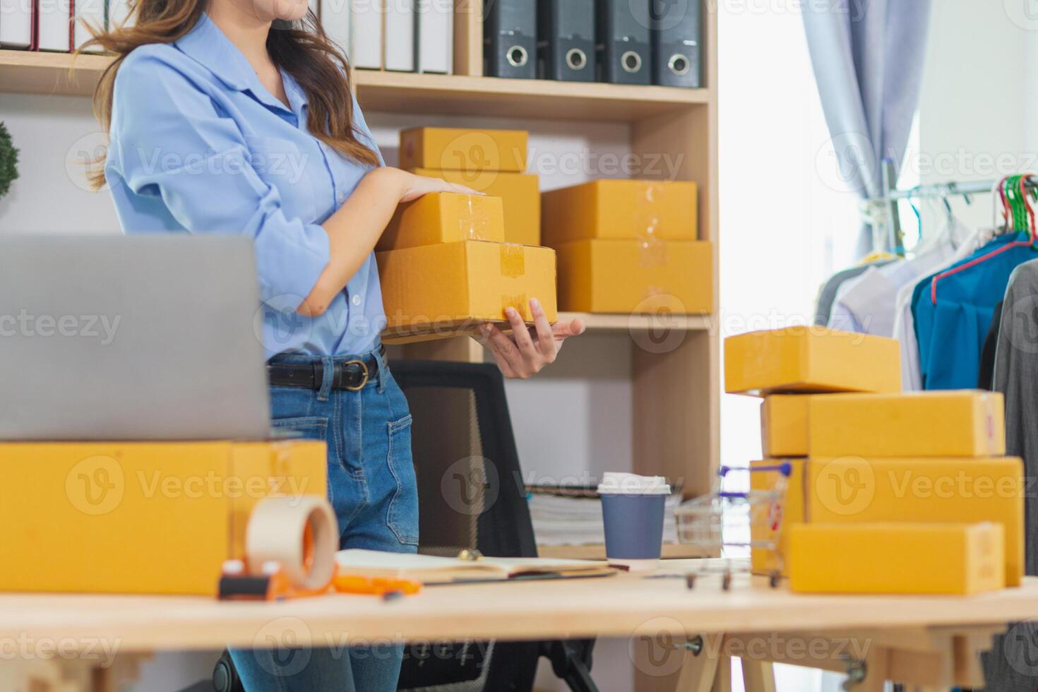 Asian woman starts small SME business using her home as Home Office and checks inventory to ensure that there are enough items to deliver to customers according to orders. Small SME Business Startup photo