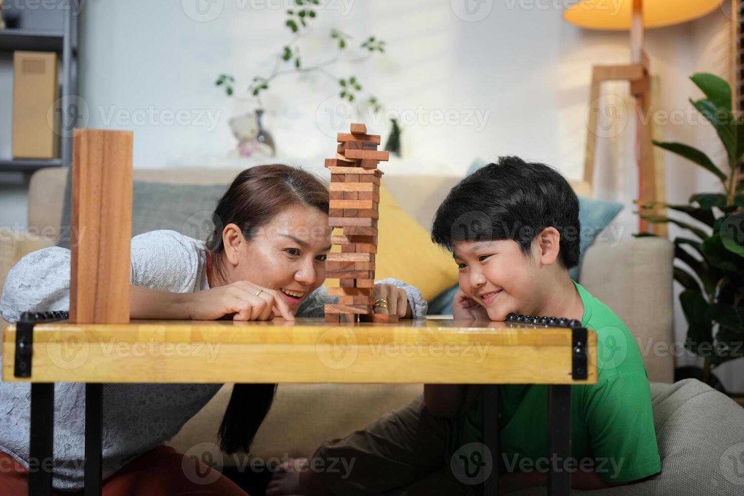 Mother and Son Playing Block Game at Home, Happy Family Bonding with Fun Indoor Game, Parent and Child Enjoying Quality Time Together photo