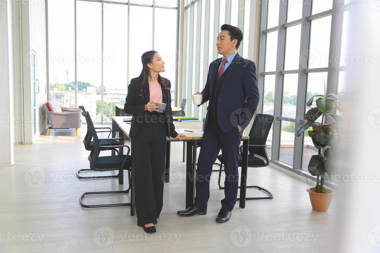 Friendly Conversation Between Coworkers in Office, Business Colleagues Enjoying Coffee Break in Modern Office, Professional Team Chatting During Work Break photo