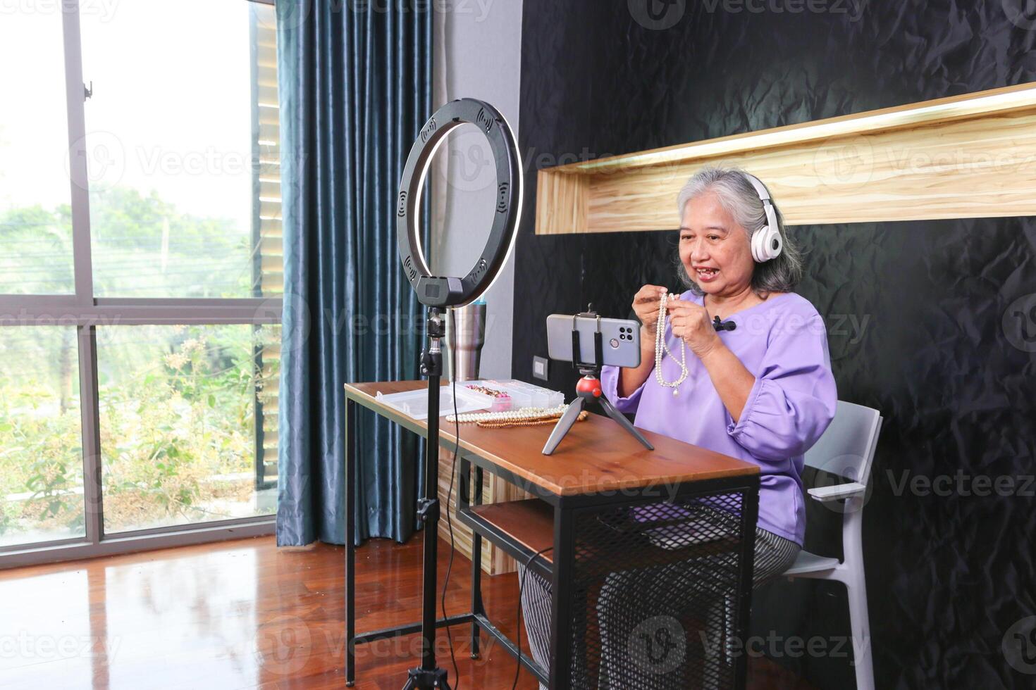 Senior Woman Creating Online Content Live Streaming or Vlogging from Home, Mature Woman Using Technology for Online Selling at Home photo