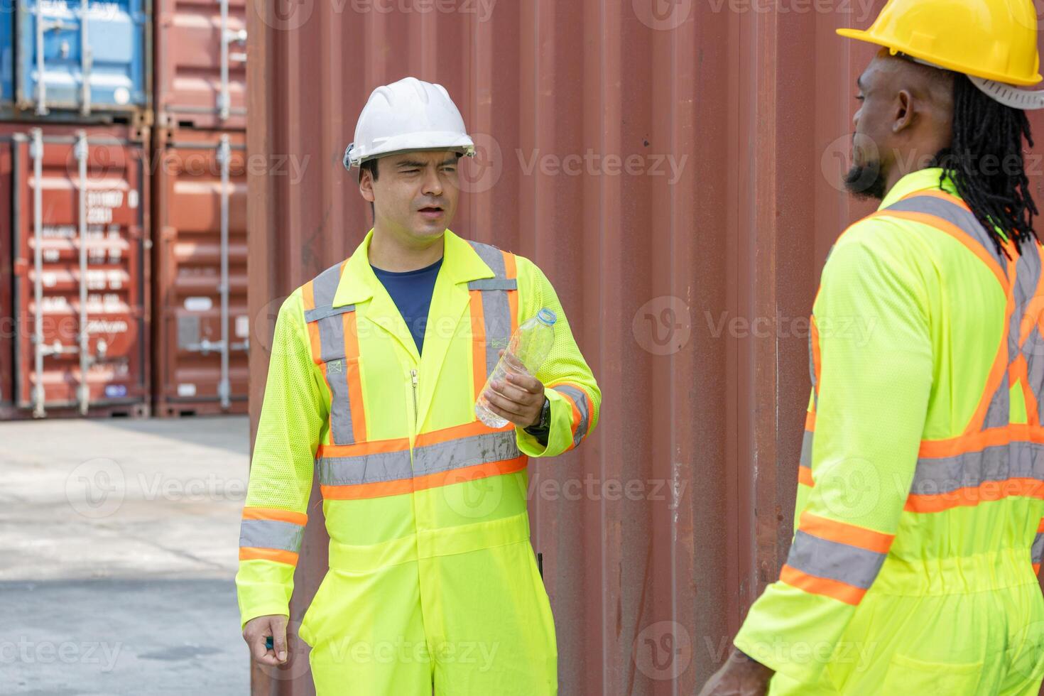 Construction Workers in Reflective Gear Discussing Project, Two Industrial Workers on Site with Shipping Containers photo