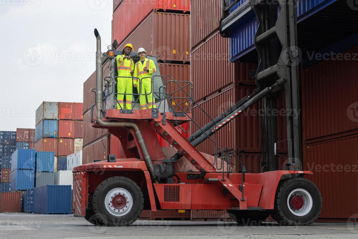 Engineer and foreman dock worker inspecting containers box at shipping yard, Inspectors standing on top of a containers handlers machine at container yard photo