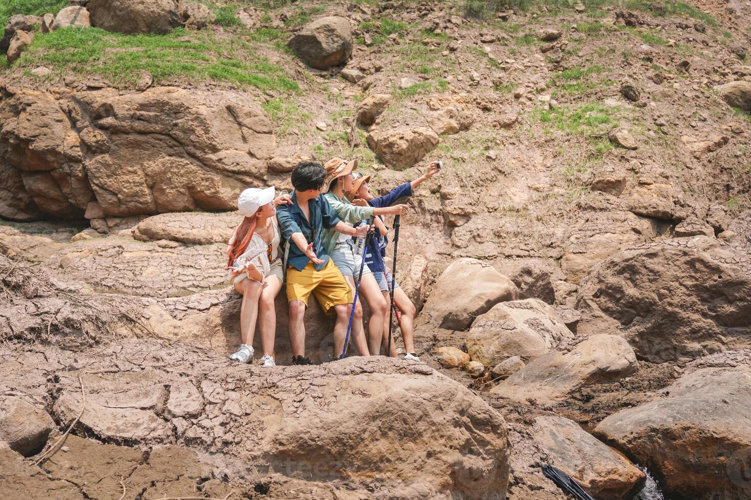 Friends Taking a Selfie on a Rocky Outdoor Adventure, Group of Hikers Exploring a Dry, Rocky Landscape, Young People Enjoying Nature on a Summer Day Trip photo