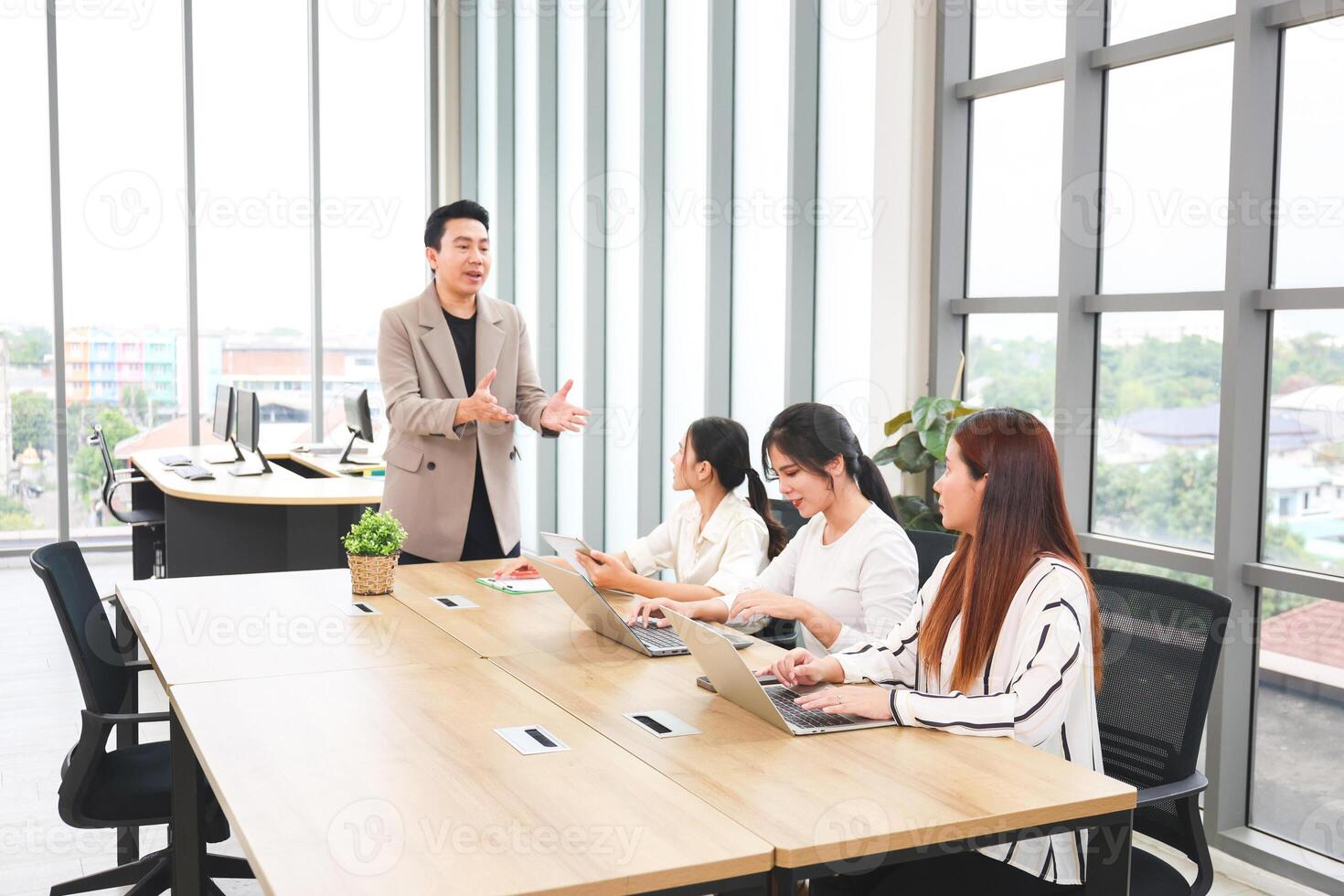 Professional Business Team Collaborating in Modern Office Meeting, Businessman Leading Discussion with Female Colleagues in Conference Room photo