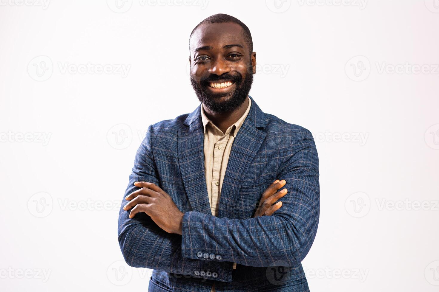 Portrait of African American businessman in suit with arms crossed standing strong and smiling, reflecting real personality and business success.Studio shot on the gray background. photo