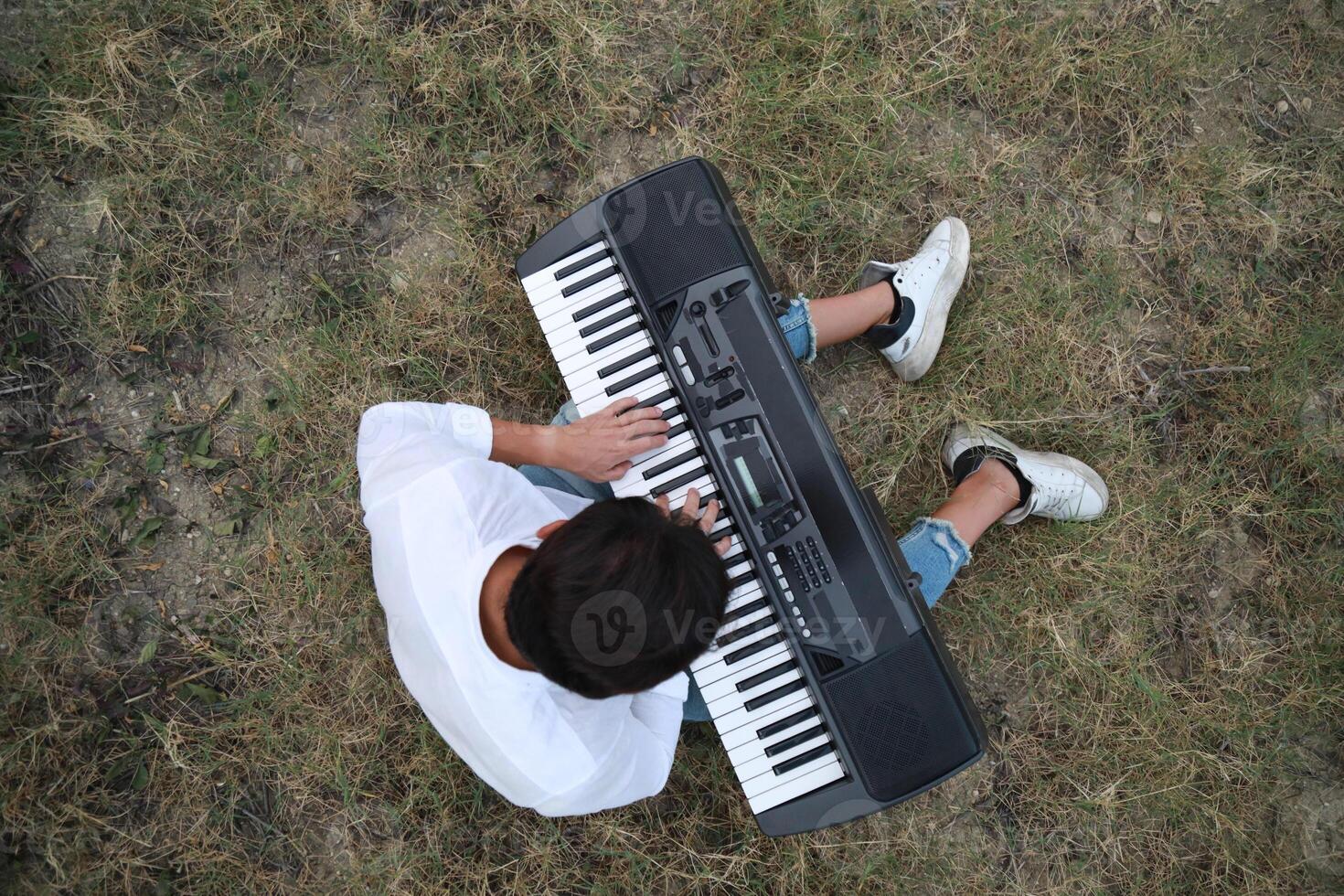 Musician Boy Plays The Keyboard Sitting In The Meadow In Calabria Countryside Outdoor photo