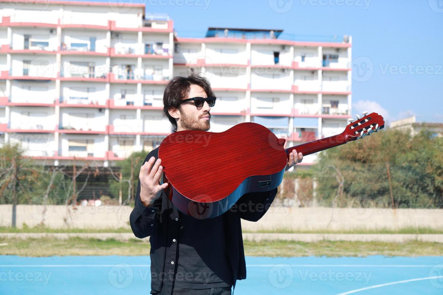 Acrobat With Classical Guitar Balancing On Foot For Street Art Show Outdoor photo