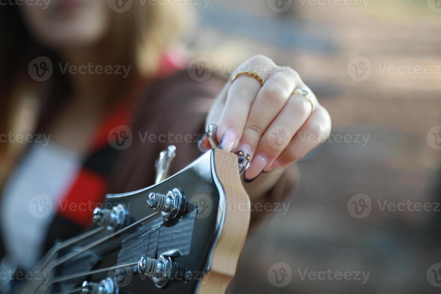 Girl Adjust Handles To Tune Bass Instrument In The Park photo