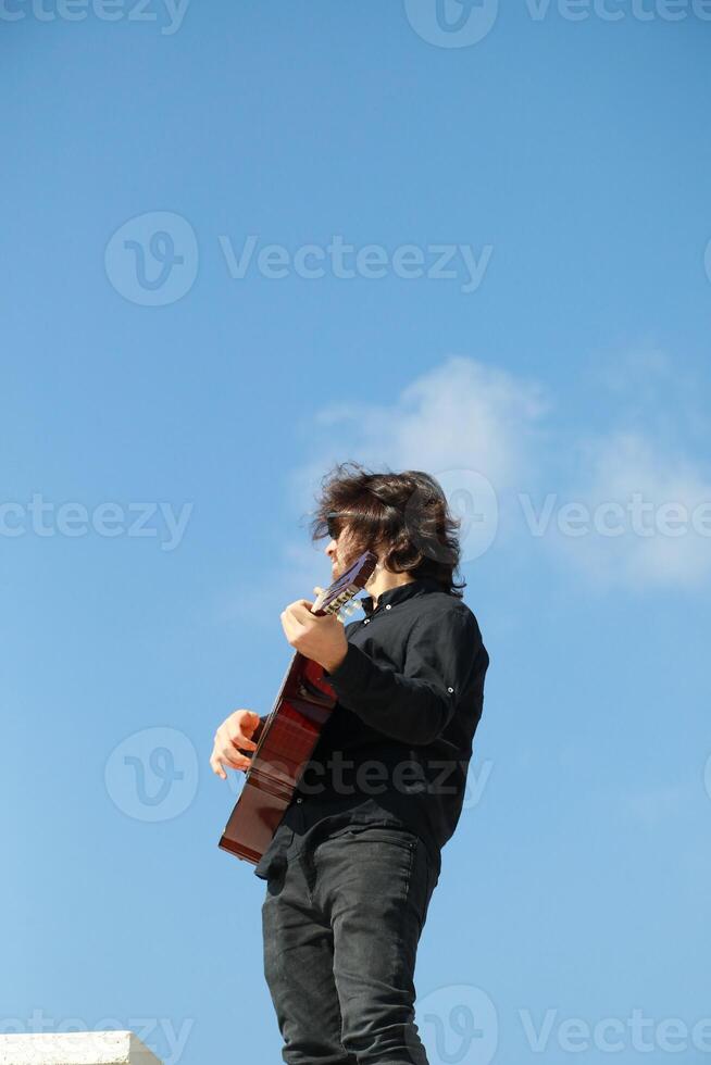 Man Plays Classical Guitar On A Day Stand In The Park Outdoor photo