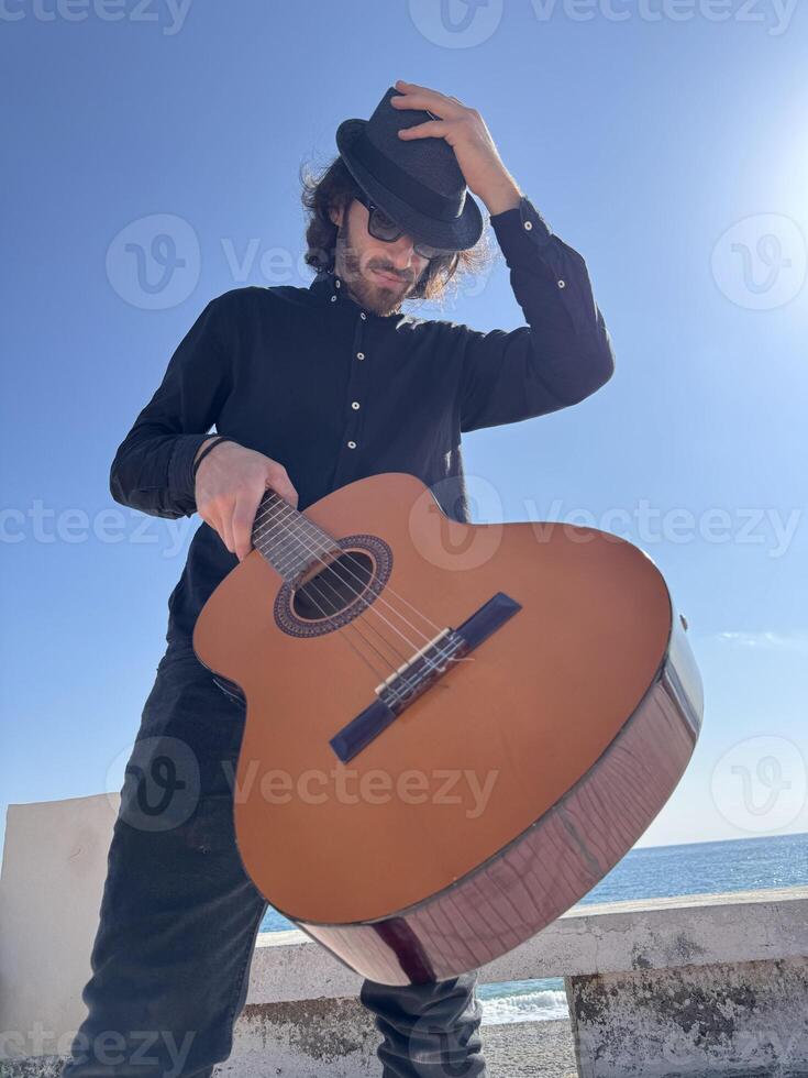 Young Man Plays Guitar On Pedestrian Crossings Of In Summer Outdoor photo