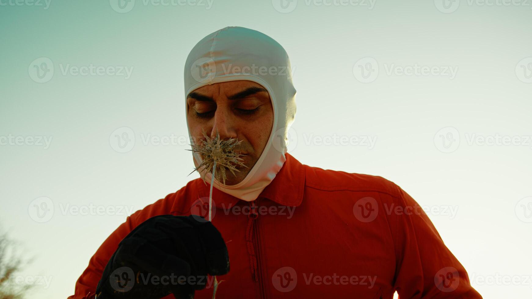 An Astronaut in an Orange Suit Smell a Poisonous Flower on Hostile Planet Outdoor photo