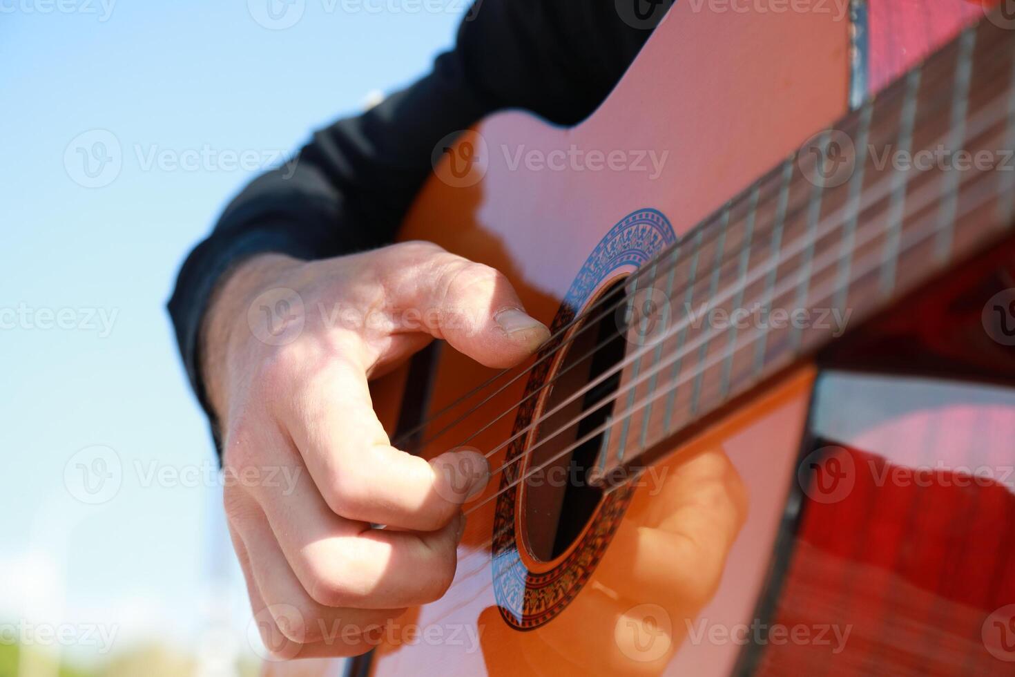 Hand Of A Man Plays Classical Guitar Outdoor On The Beach Near The Sea In Summer photo