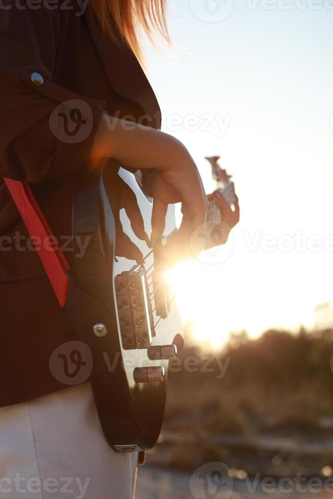 Girl Plays Bass Music On The Beach At Sunset Near Ocean Outdoor photo