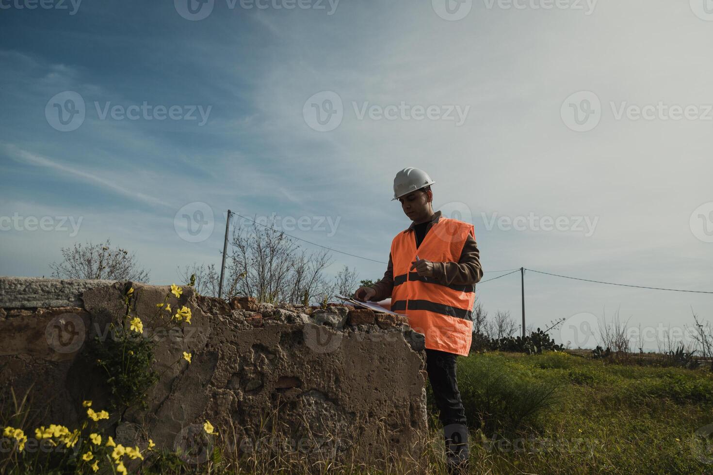 Engineer Looking Around The Construction Site And Taking Notes photo