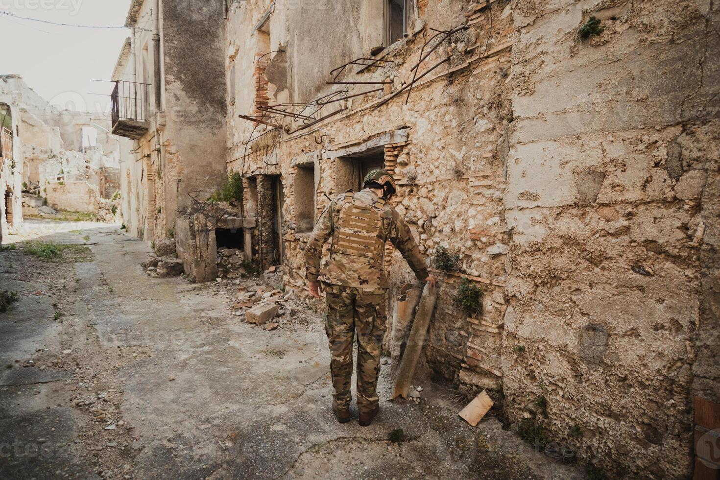 Soldier Checks The Houses Of A City Devastated By Bombings photo