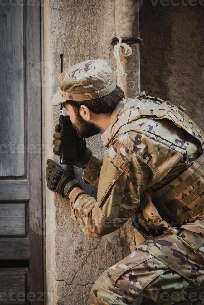 Soldier Communicates With Walkie Talkie Before Going Into A House photo