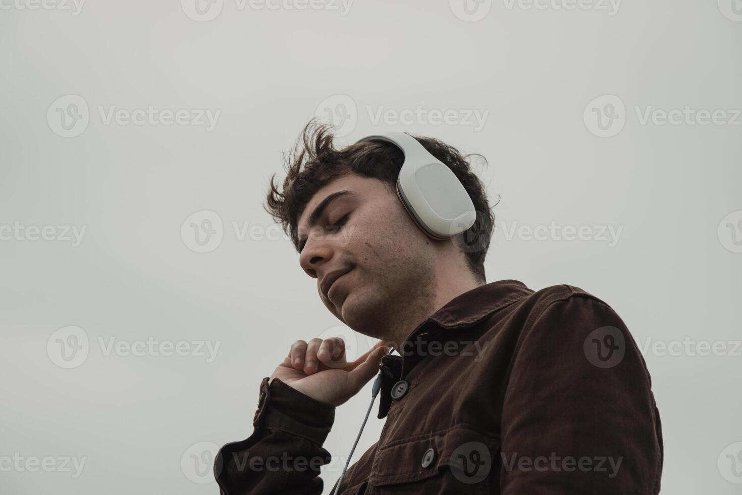 Man Relaxing On The Shore During Winter While Listening Music photo