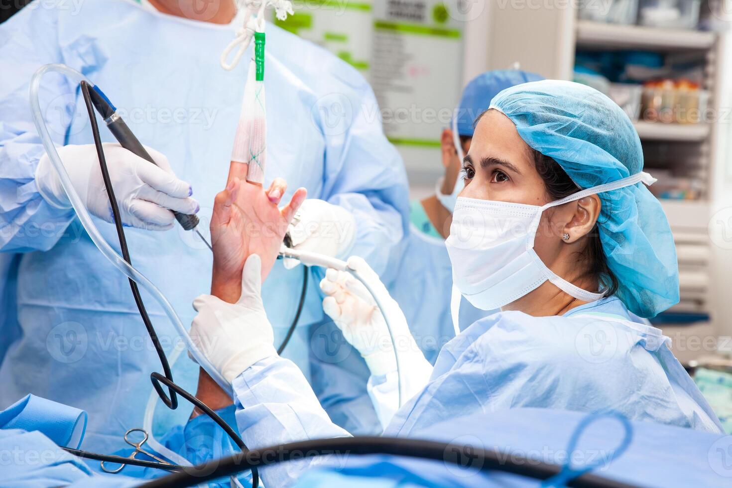 Orthopedic surgeons makinga wrist arthroscopy on a male patient. Female doctor performing a surgery. Orthopedic surgeon. Surgery and insurance concept. photo