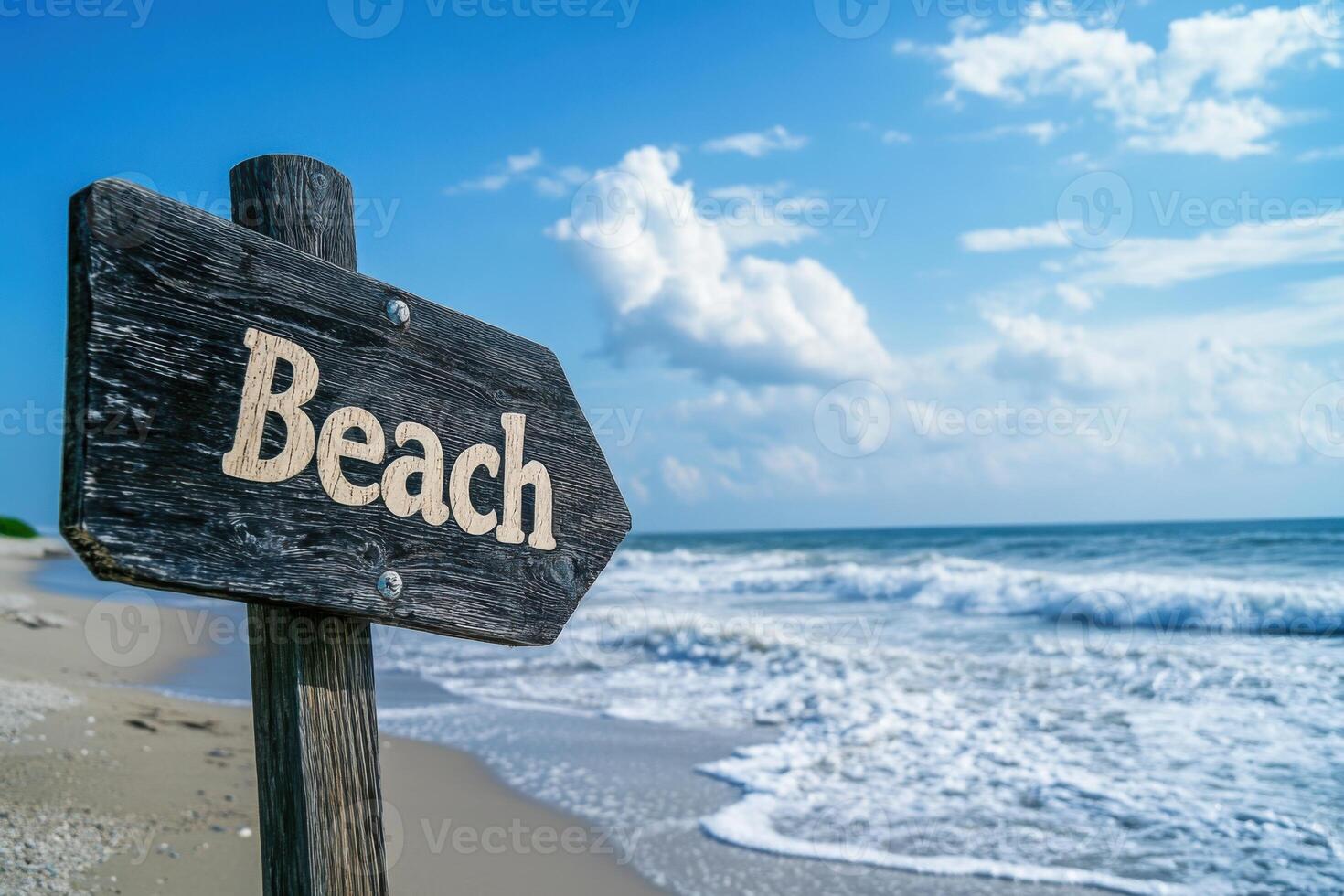 Rustic wooden sign guiding to the tranquil beach and ocean waves under a bright sky photo