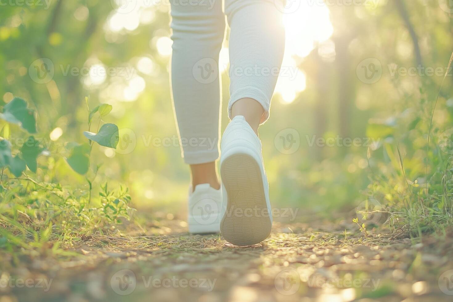 Enjoying a peaceful walk on a forest path surrounded by greenery and sunlight photo