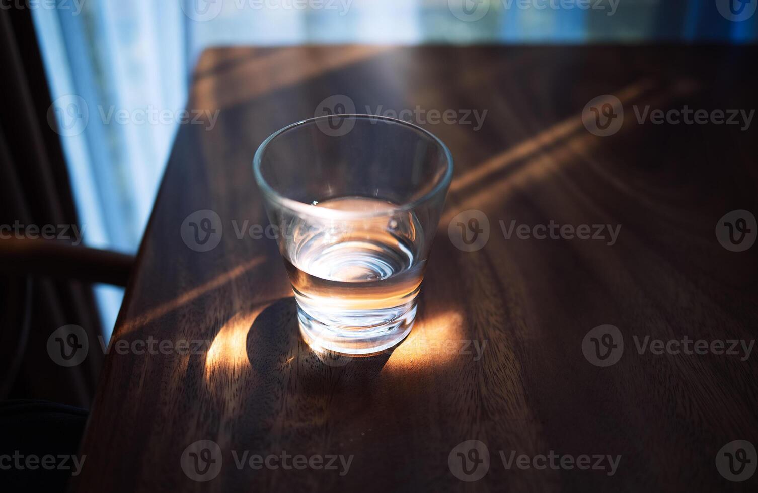 Close up of a glass of clean water on a wooden table photo