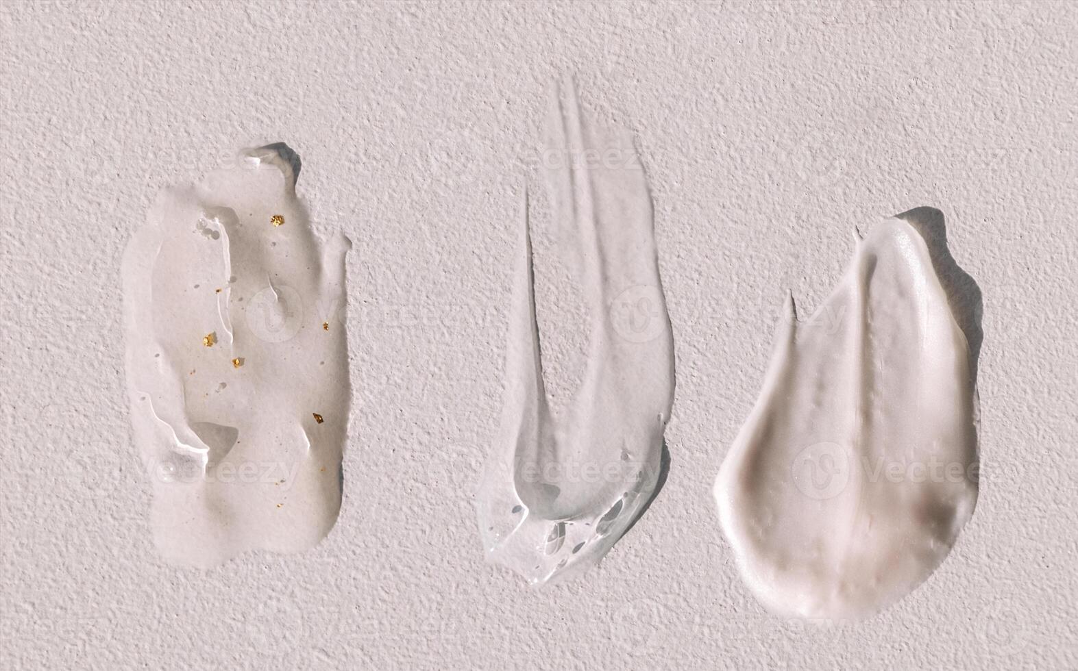 Different texture of gel and cream on a light background. Transparent serum with bubbles and colloidal gold. photo