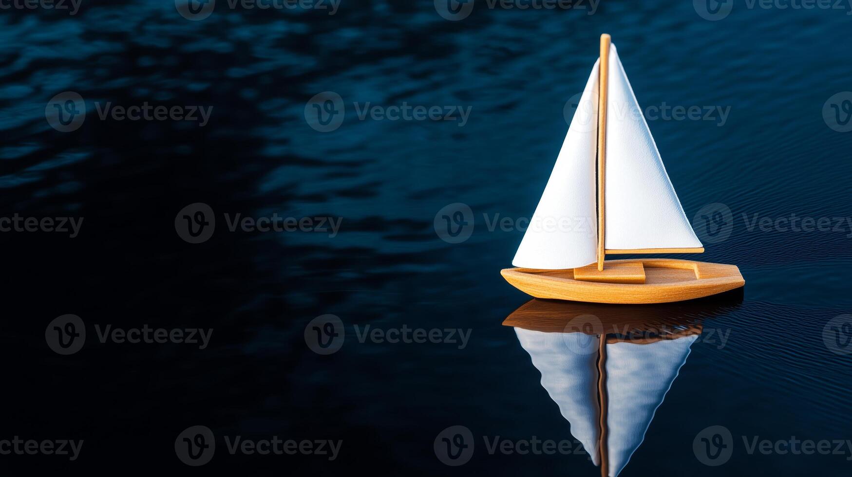 A small toy boat floating on a body of water photo