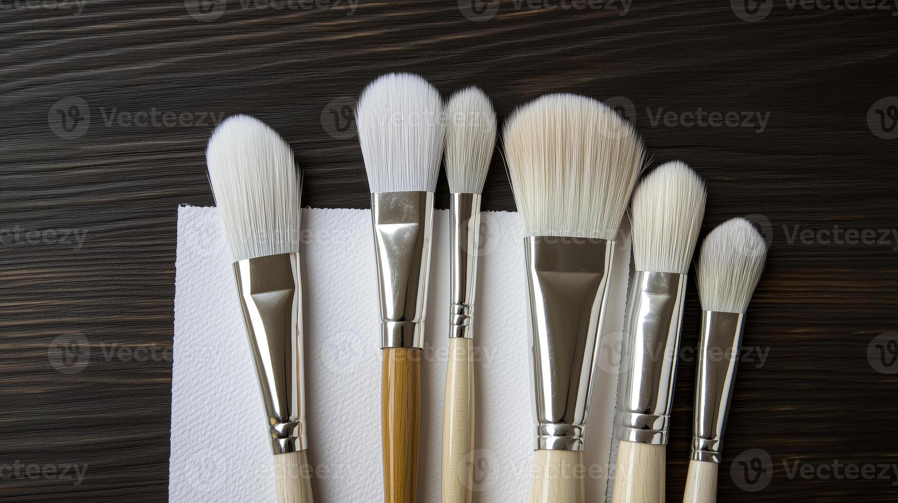 Five brushes are lined up on a napkin photo