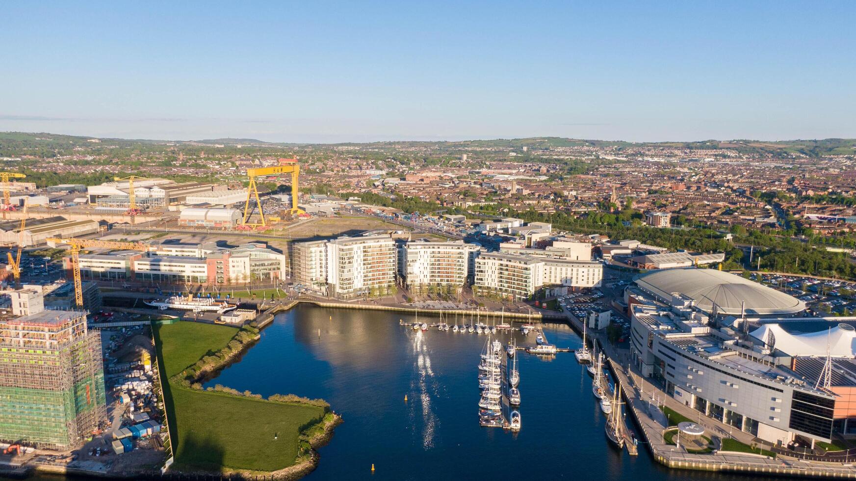 4.5.25 Belfast UK Aerial view on Lagan River and buildings in City centre of Belfast Northern Ireland. Drone photo, high angle view of town. Harland and Wolff Shipyard and Docks. photo