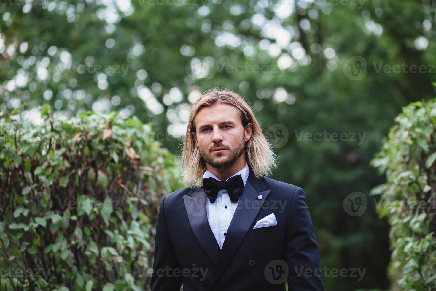 Portrait of young bridegroom with elegant stylish haircut photo