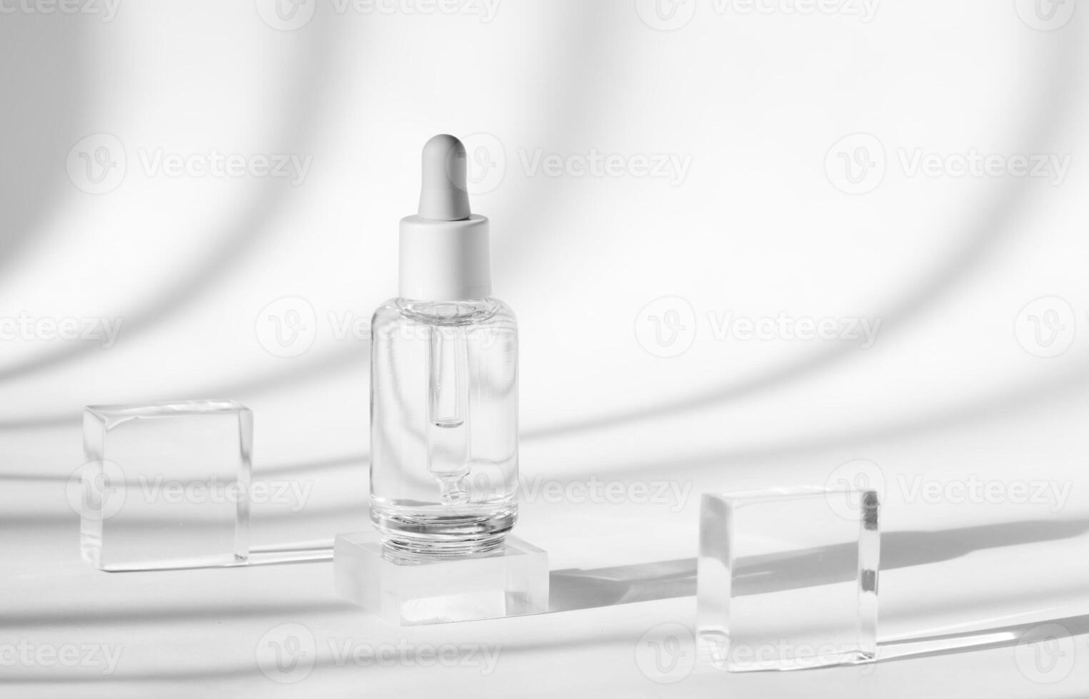 clear serum bottle with crystal blocks and shadows photo