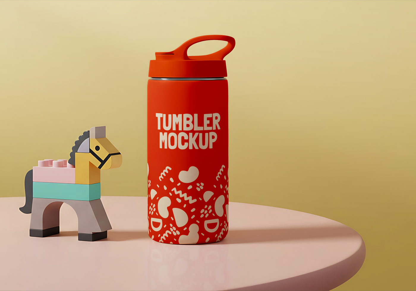 A red tumbler mockup with a playful design sits on a table next to a toy horse psd